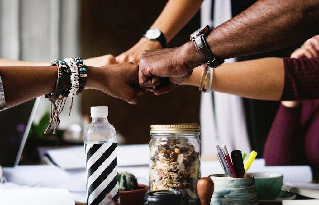 A diverse team joining hands in collaboration